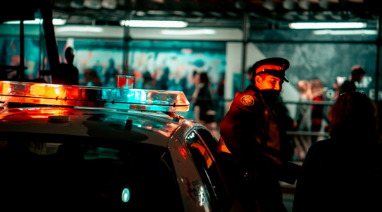 police officer standing by police car at night