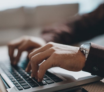 photo of someone typing on a laptop